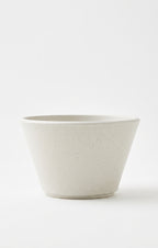 A minimalist, tapered ceramic planter or bowl in a light warm gray speckled finish, photographed against a seamless white background.